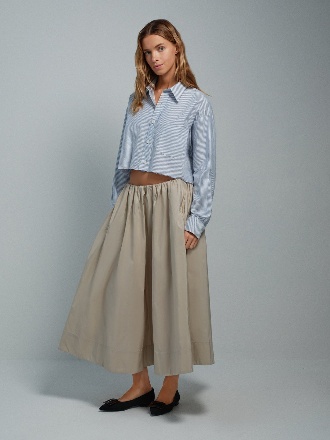 On-model front view of beige taffeta Midi skirt with gathered waist and pockets.