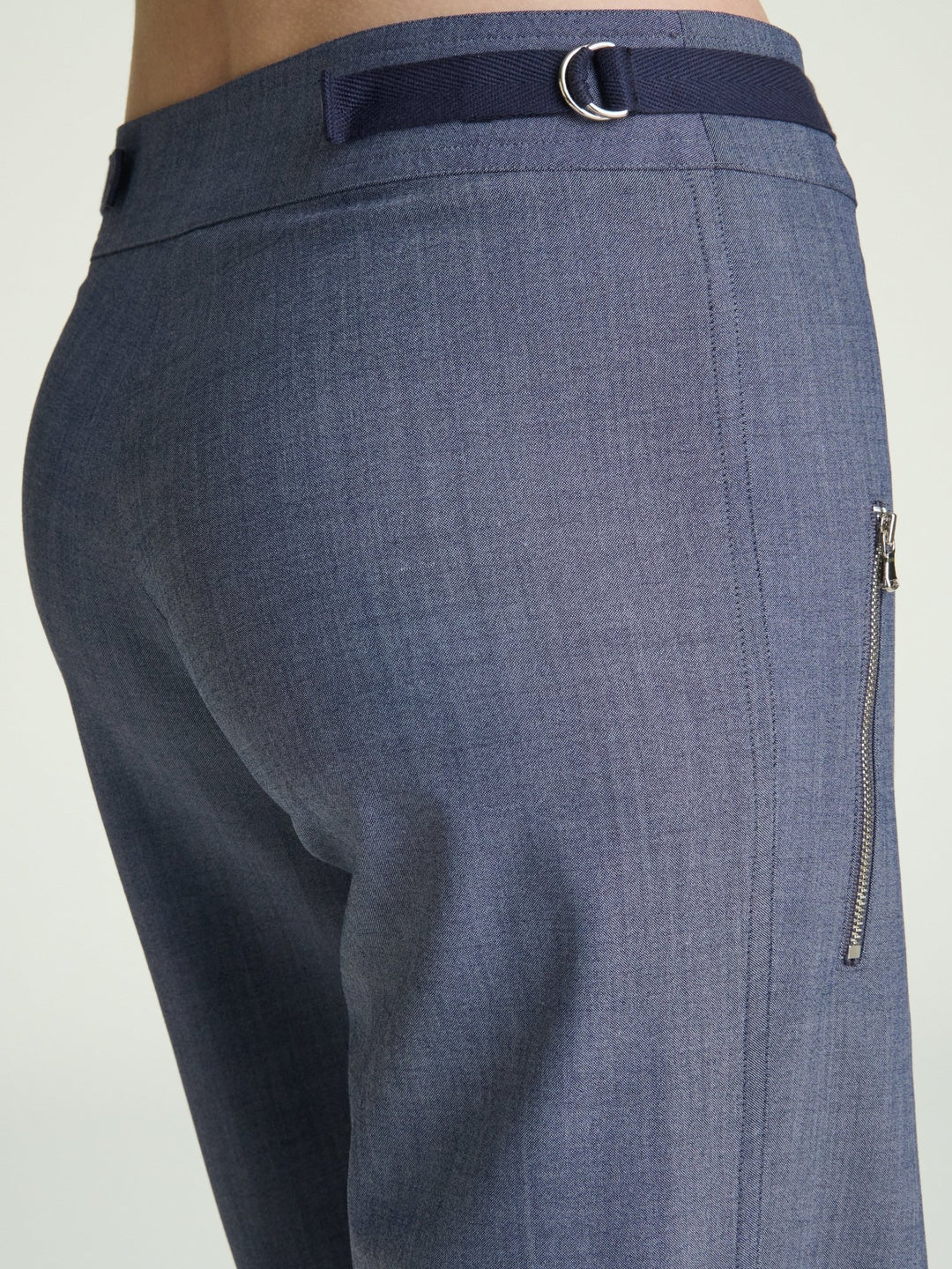 detail photo of blue trousers with nickel D ring and herringbone ribbon on trouser waistband