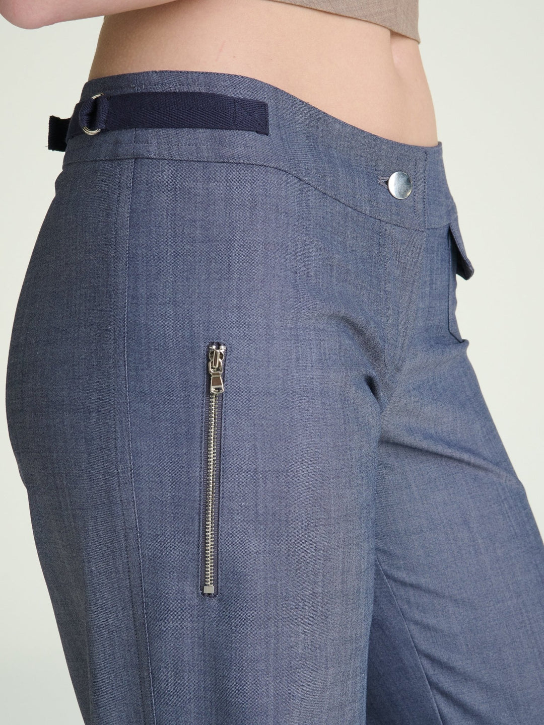 zoomed in photo of model wearing fitted heather blue trousers with metal trims