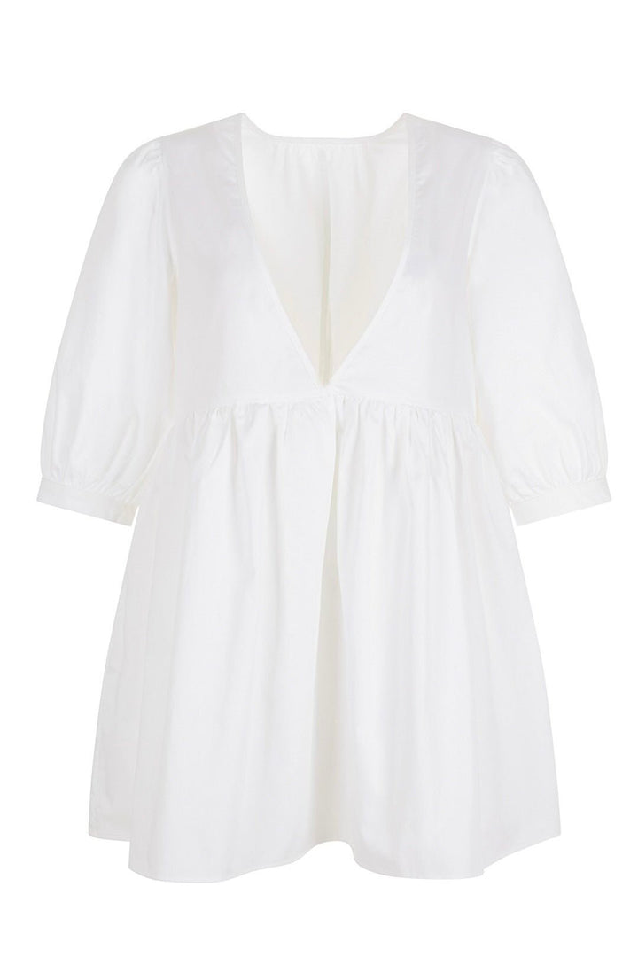 White mini dress with a deep V-neckline and three-quarter length puff sleeves displayed on a white background.