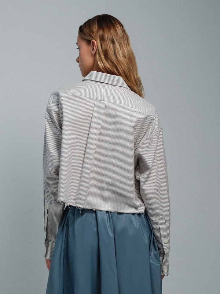 Back on-model view of brown striped raw-edge oxford shirt with cropped raw hem.