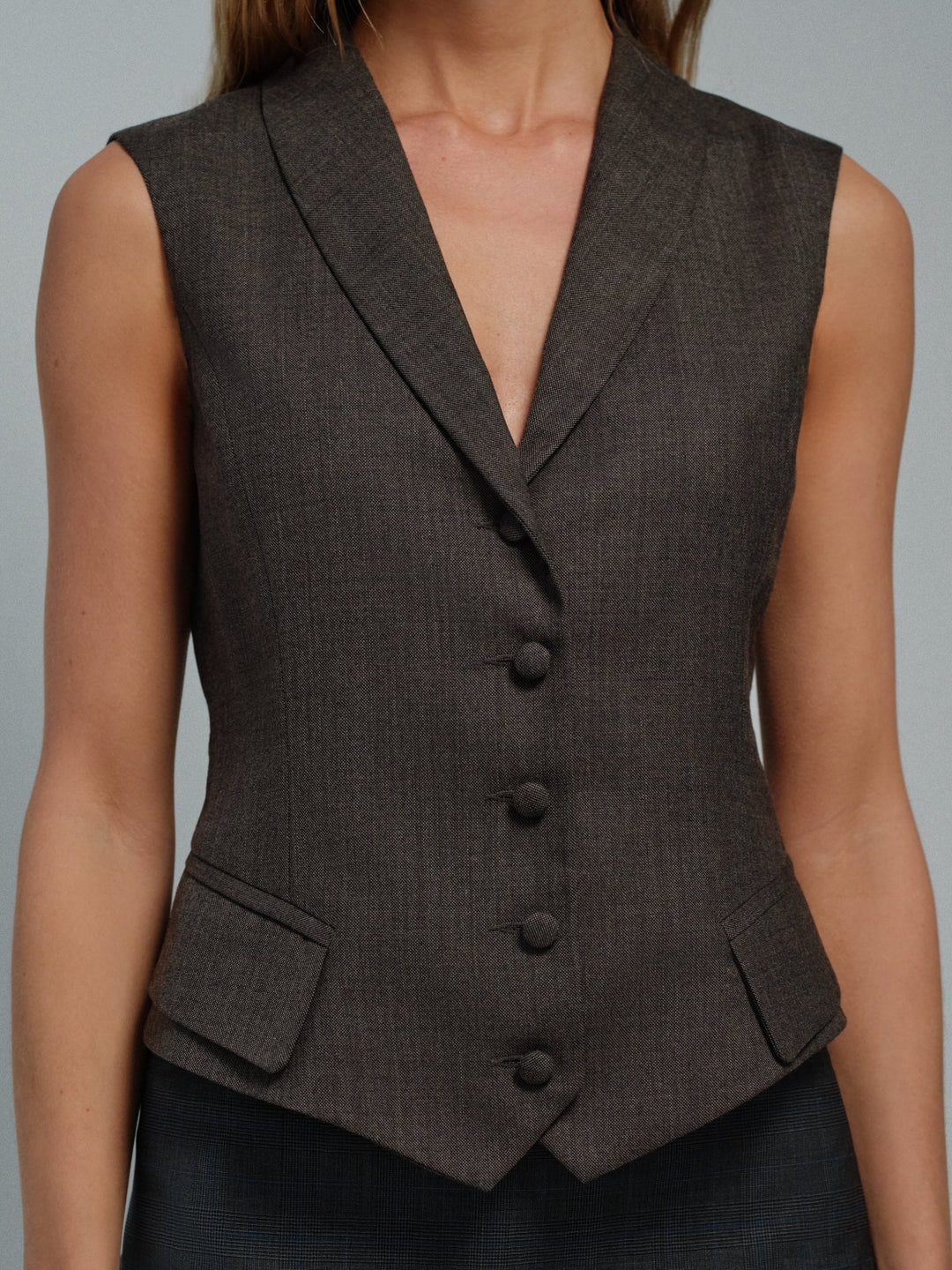 Close-up of the Darling waistcoat in charcoal showing notched collar, covered buttons and flap pockets.