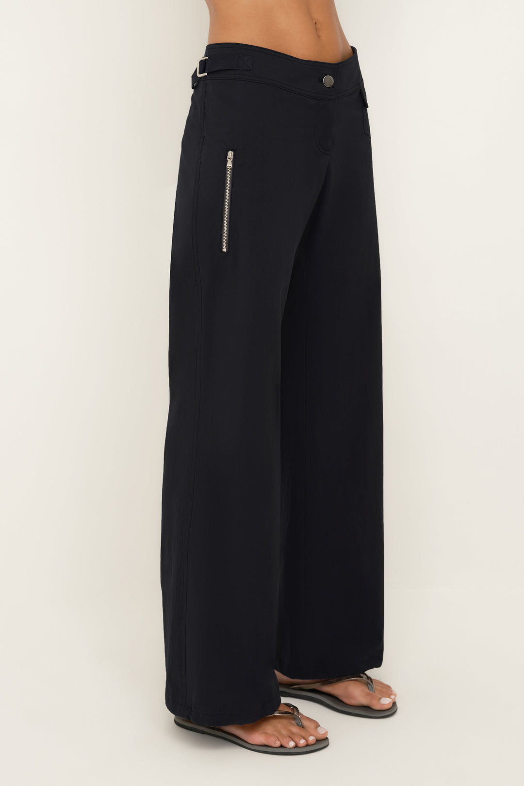Black wide-leg pants with a zipper on a grey background