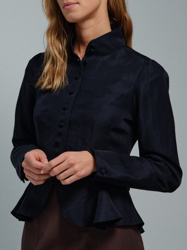Dark blue jacket blouse worn by a person on a gray background