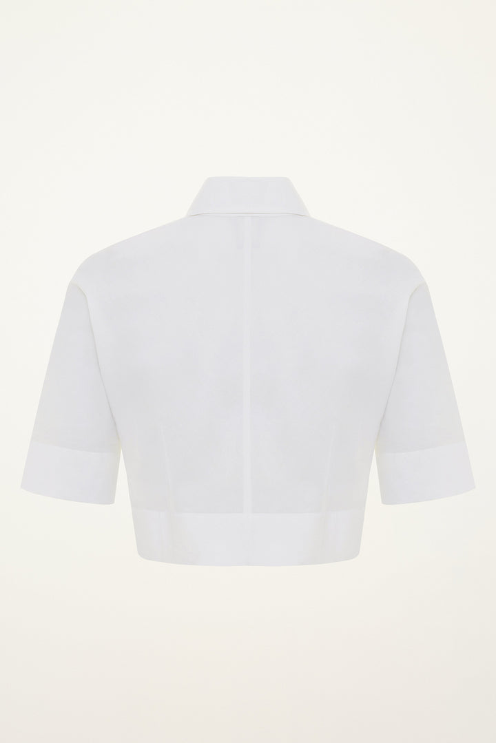 White short-sleeve cotton button-down cropepd shirt on a light gray background