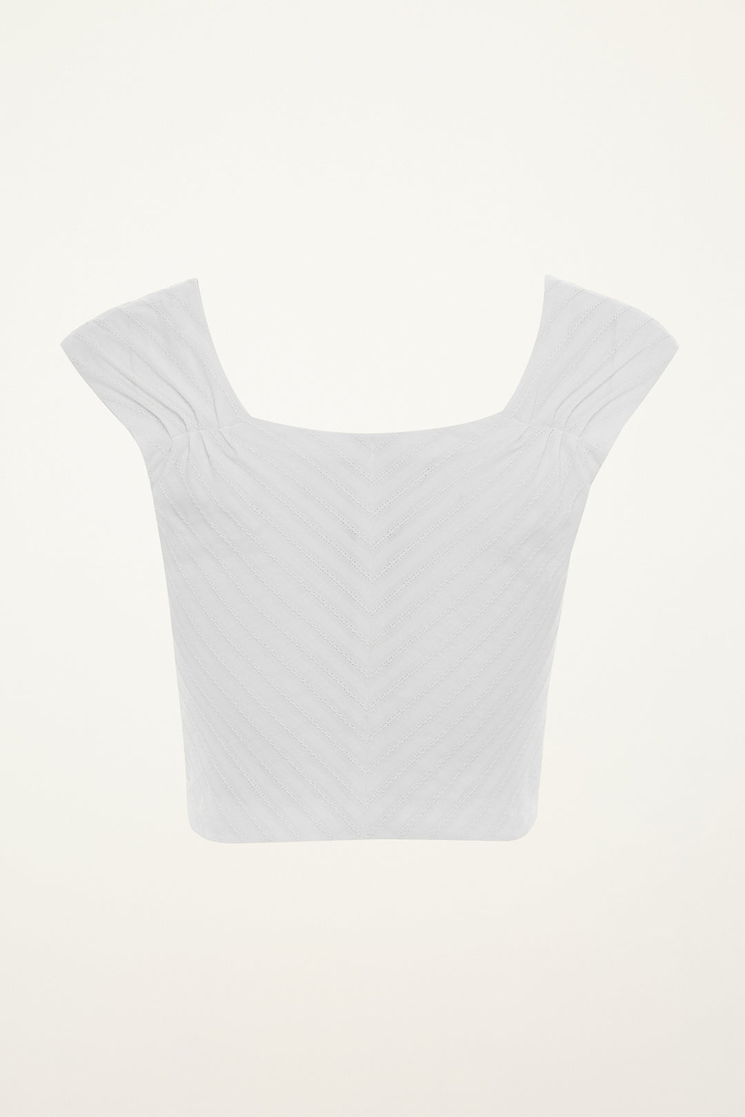 White crop top on a mannequin against a grey background
