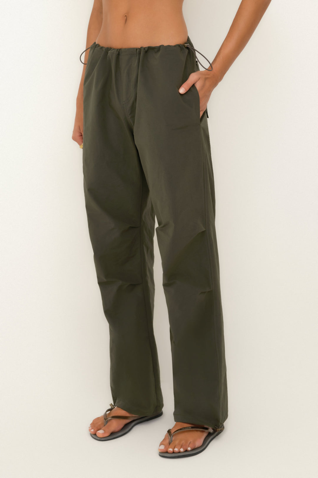 Person wearing olive green pants on a white background