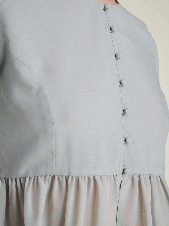 fabric covered buttons on a lightweight light grey blouse