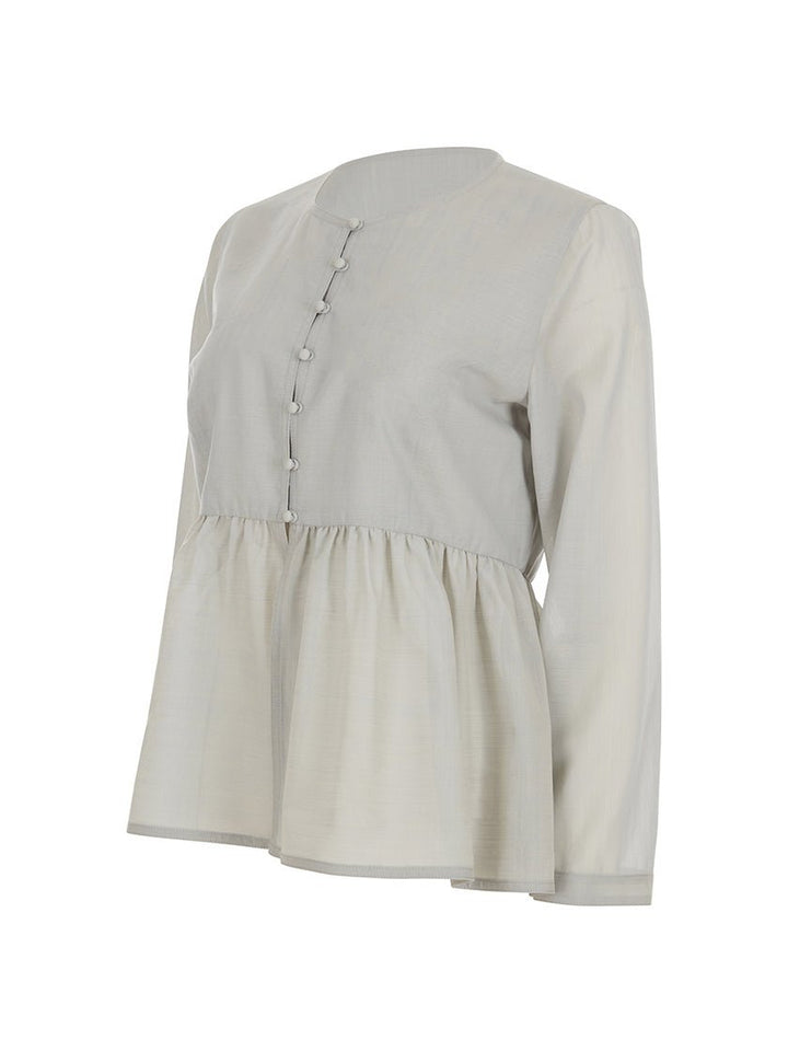 Side view of light gray, long-sleeved, peplum-style top against a white background. 