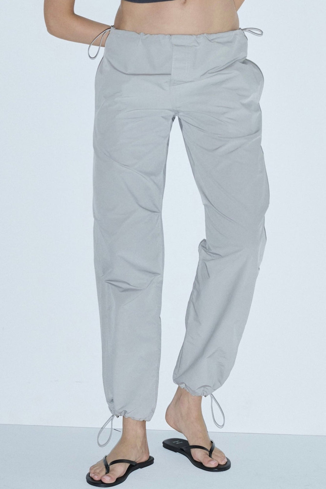 A pair of space grey luxury parachute pants with drawstrings and a relaxed fit.