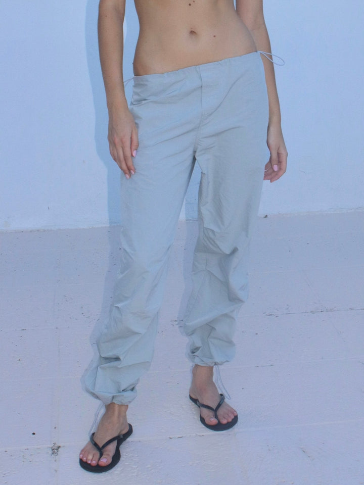 Model wearing light grey drawstring pants with a loose, relaxed fit.