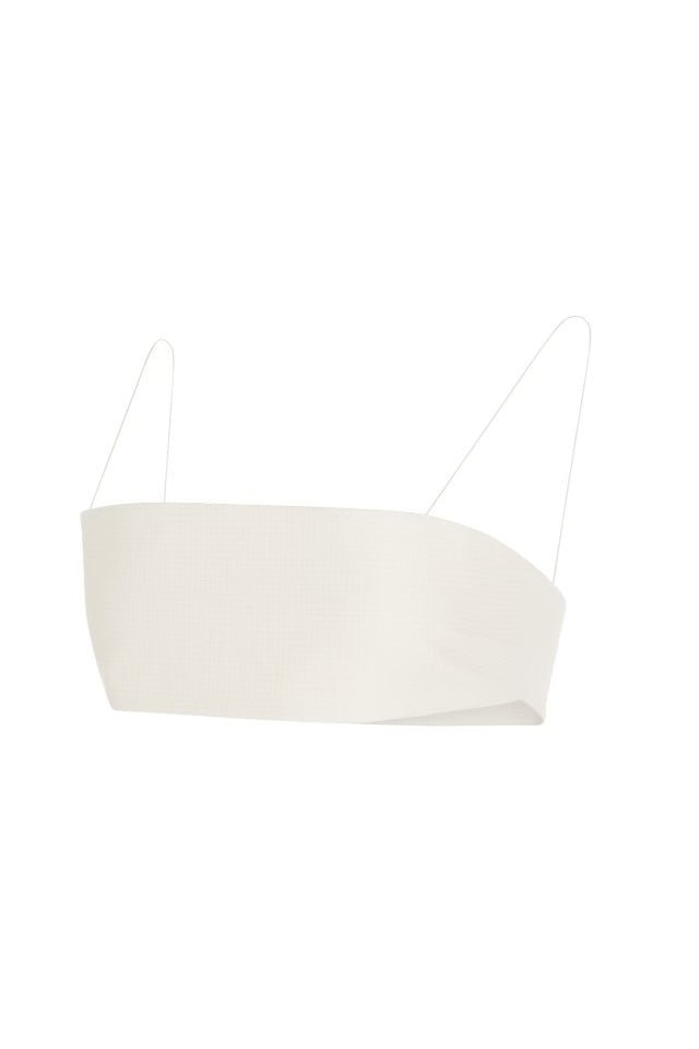 White bandeau top with thin spaghetti straps, set against a plain grey background.