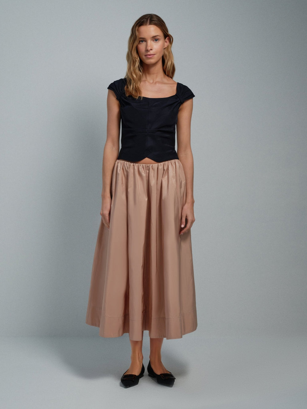 Women’s pink taffeta midi skirt, full A-line silhouette, front on-model.