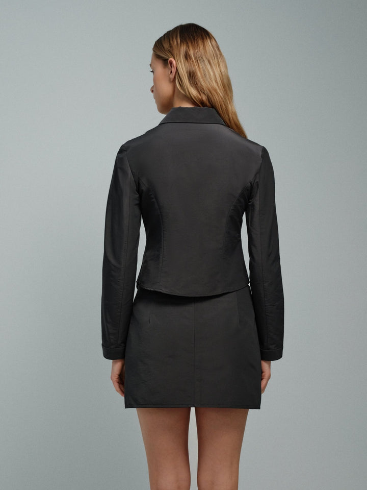 Back on-model view of slate slim zip jacket, waist-length with pointed collar.