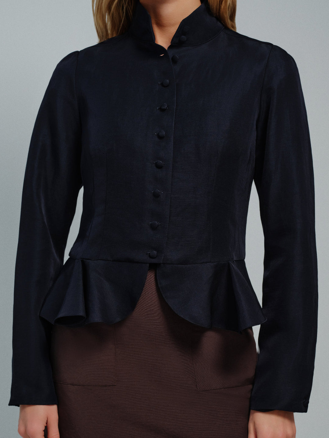 Dark blue peplum blouse with buttons on a gray background