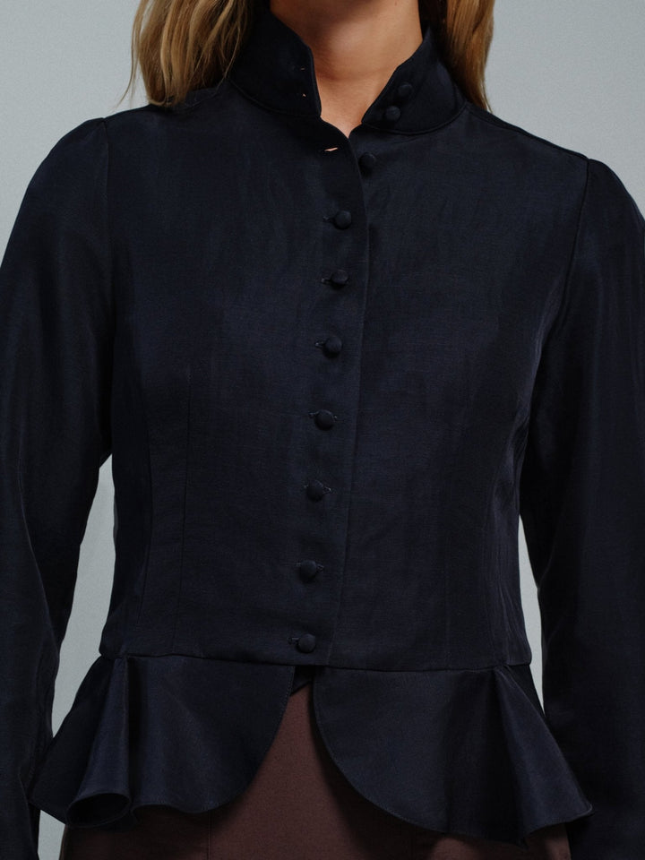 Dark blue button-up shirt with a peplum waist on a gray background