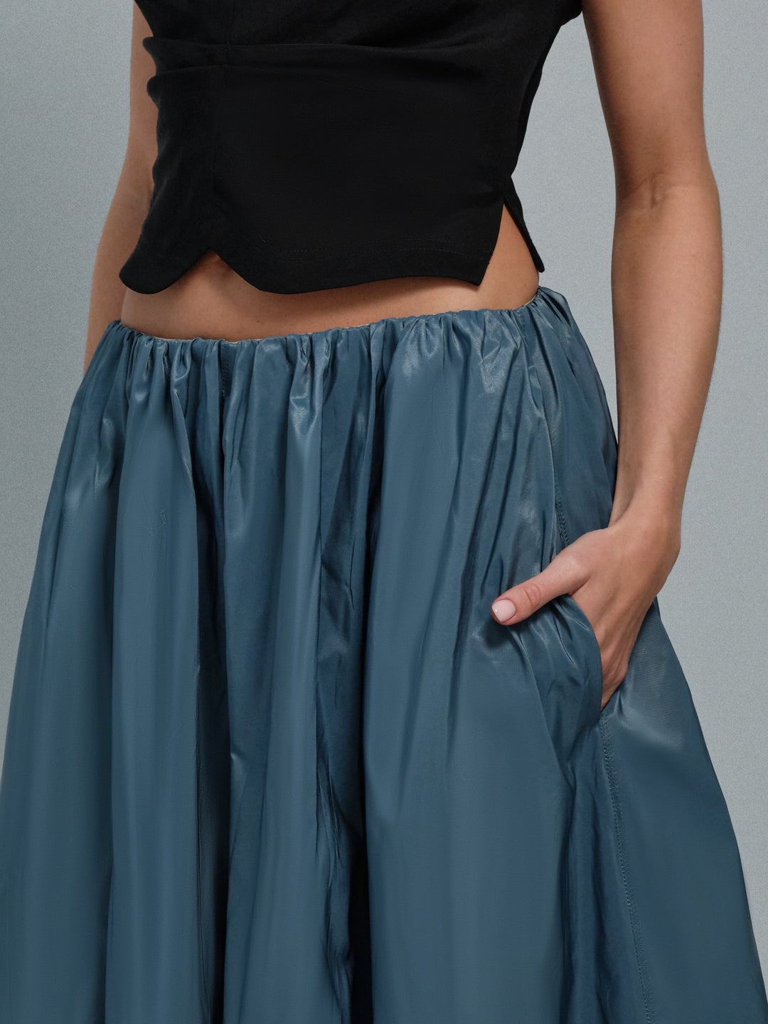 Close-up of gathered waistband and pocket on teal taffeta midi skirt.