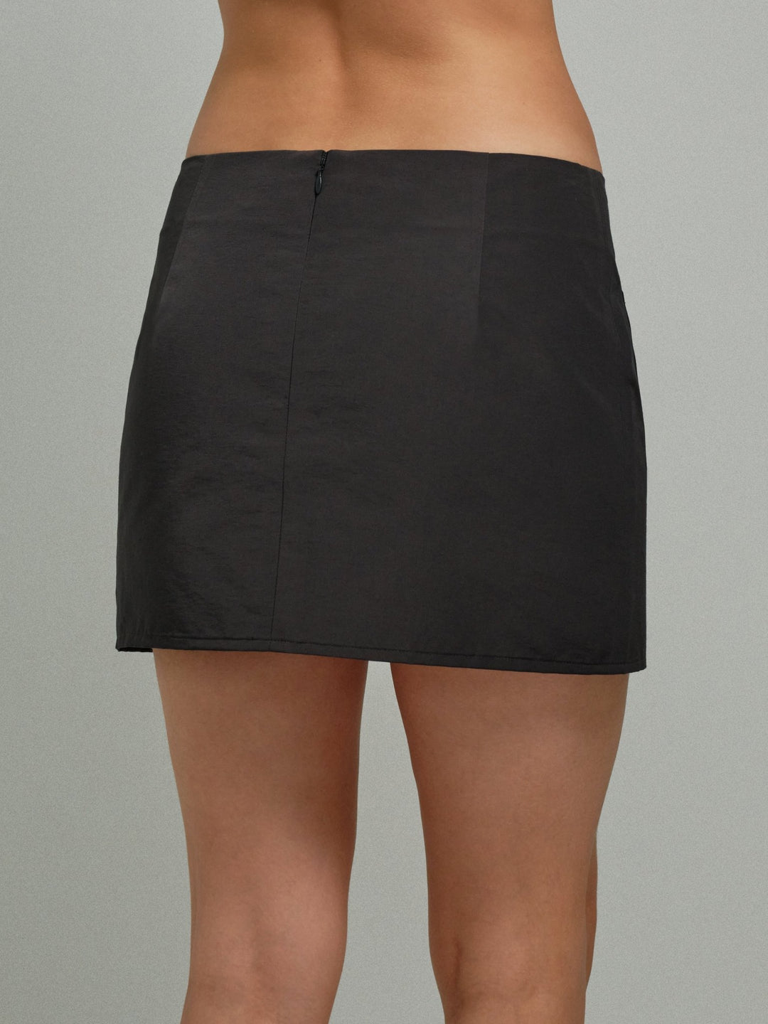 dark gray skirt worn by a person on a gray background